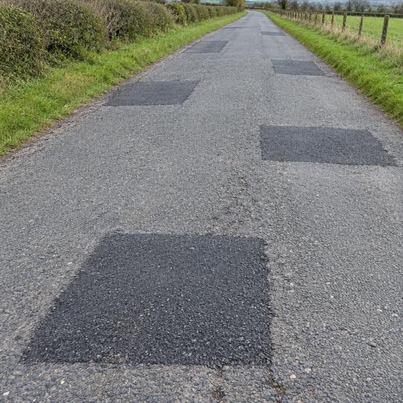 Road with several completed asphalt repair patches