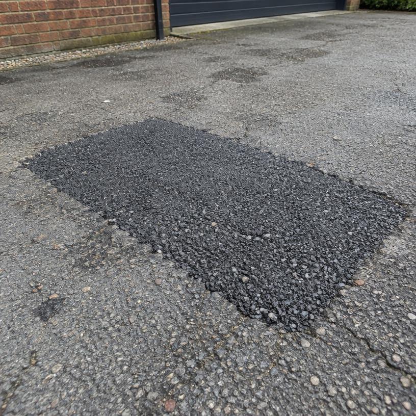 Tarmac patch repair on a weathered driveway